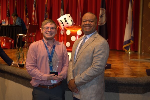 A man receiving an award from another man.