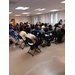 Group in chairs listening to person speaking.