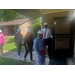 A group of peope walk into a residential unit with hardhats on. 