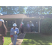 Men and women, each wearing a hardhat walk down a sidewalk away from a residential unit. 